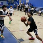 Young boys playing basketball in a gymnasium.