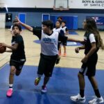 Kids playing basketball in a gymnasium.