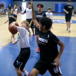 Youth basketball game with players competing intensely near the hoop.