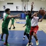 Young basketball players competing intensely in a gym.