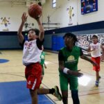 Youth basketball player jumps to score a basket.
