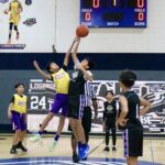 Youth basketball players compete for the ball during a game.