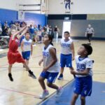 Young basketball players in action during a game in a gym.