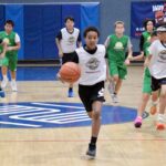 Young basketball player dribbling on indoor court during game.