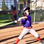 Young baseball player preparing to hit a pitch during a game.