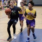 Young basketball players competing intensely during a game.
