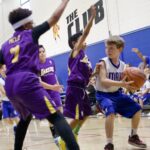 Youth basketball players compete intensely during a game.