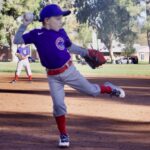 Young baseball player pitching on the field.
