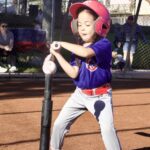 Young child playing baseball, preparing to swing the bat.