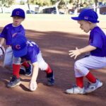 Young kids playing baseball on a sunny day.