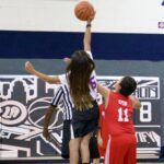 Two girls competing for the basketball during a game.