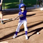 Young child ready to hit a baseball during a game.