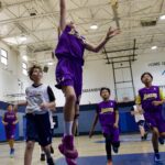 Youth basketball game with players in action inside a gym.