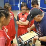Coach explaining a strategy to young basketball players.