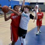 Young boys playing basketball in a gym during a game.