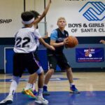 Youth basketball players in action during a game at Boys & Girls Club gym.