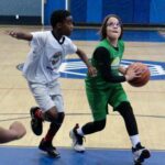 Two female basketball players competing intensely during a game.