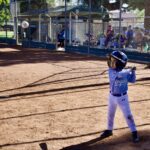 Young baseball player preparing to bat during a game.