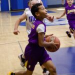 Youth basketball player driving to the basket during a game.