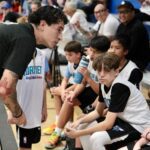 Coach intensely talks to his young basketball team during a game.