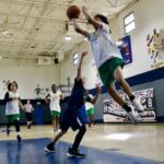 Young basketball players compete in an indoor gym game.