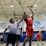 Young basketball players compete actively during a game in a gym.