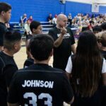 Coach giving instructions to young basketball players during a game.