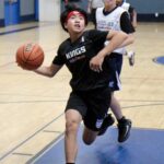Young basketball player driving to the basket during a game.