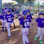 Youth baseball team giving high-fives after a game.