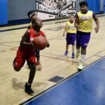 Young basketball player driving to the hoop during a game.