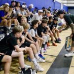 Youth basketball team listens to coach during game timeout.