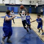Youth basketball player drives to the hoop during a game.