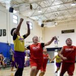 Youth basketball players competing intensely in a gymnasium game.