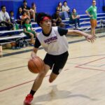 Young basketball player dribbling on the court during a game.