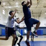 Young boys playing basketball in a gym.