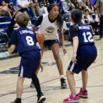 Young girls playing basketball in a gym during a game.