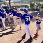 Young baseball players celebrating on the field during a game.