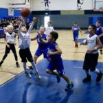 Youth basketball players compete intensely during a game.