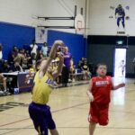 Young basketball players compete in a gym during a game.
