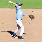 Youth baseball player throwing a ball on the field.