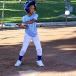 Young baseball player preparing to hit the ball during a game.
