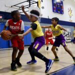 Youth basketball game with active defense and dribbling.